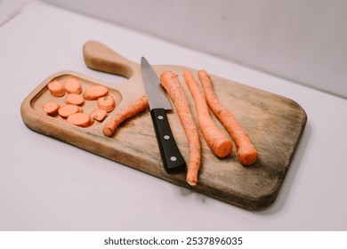 Chopped carrots on a wooden cutting board surrounded by a variety of fresh vegetables, symbolizing World Vegan Day and promoting healthy, plant-based eating - Powered by Shutterstock