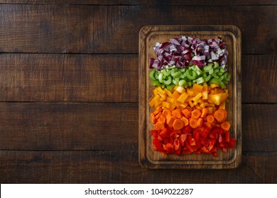 Chopped Fresh Vegetables Arranged On Cutting Board On Dark Wooden Table With Copy Space, Top View