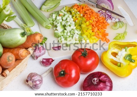 Chopped fresh vegetables for cooking. Carrots, zucchini, celery, bell pepper, tomatoes, garlic and red onion on a cutting board. Culinary ingredients. Healthy eating. Diet. Selective focus