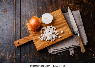 Chopped onion on wooden cutting board and kitchen knife