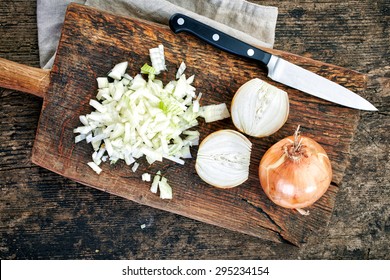 chopped onions on wooden cutting board, top view