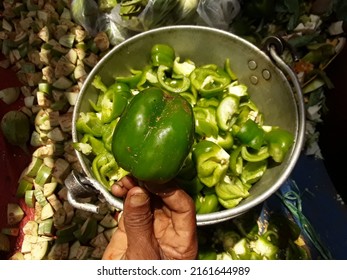 Chopped up pieces of green capsicum pepper. Capsicum standing in the hand of a person.Sliced ​​Capsicum Steel Pots. 