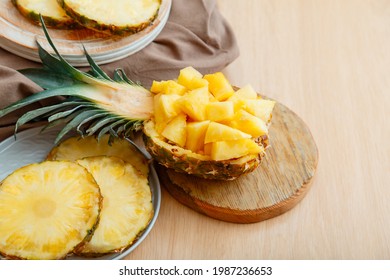 Chopped pineapple salad in half pineapple. Fresh delicious pineapple cut into pieces. Tasty summer pineapple sliced fruit dessert with ingredients on kitchen table. - Powered by Shutterstock