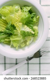 Chopped Romaine Lettuce In White Bowl With Fork In Vertical Format