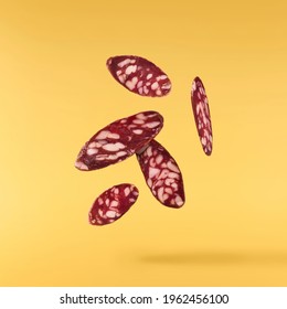 Chopped Sausage Falling In The Air Isolated On Yellow Background. Food Levitation Concept. High Resolution Image