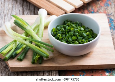 Chopped Spring Onions In White Bowl On Wooden Table