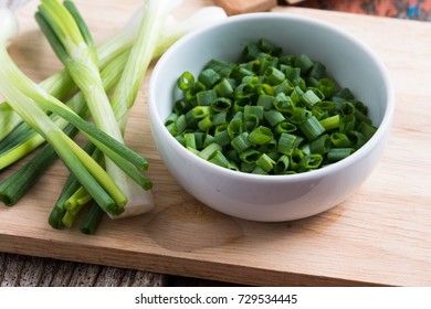 Chopped Spring Onions In White Bowl On Wooden Table