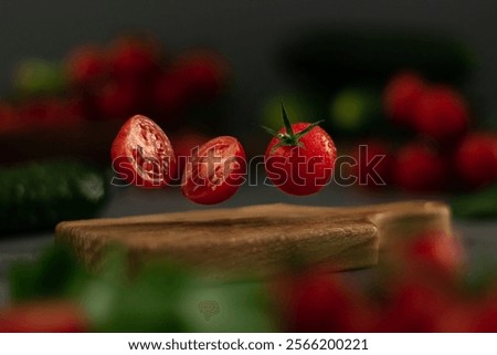 Chopped tomatoes hover elegantly above a wooden cutting board, glistening with droplets of water. More cherry tomatoes and vegetables create a vibrant backdrop.