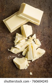 Chopped White Chocolate On Rusty Background.