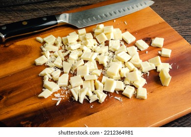 Chopped White Chocolate on a Wood Cutting Board: Pieces of white chocolate with a kitchen knife on a wooden carving board - Powered by Shutterstock