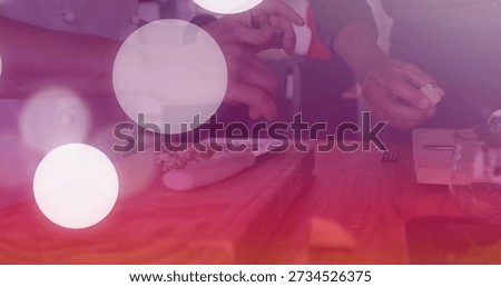 Chopping chefs' hands with white jacket sleeves slicing garlic in kitchen on cutting board, knife. Culinary, foodprep, teamwork, collaboration, bokeh, warmth, countertop