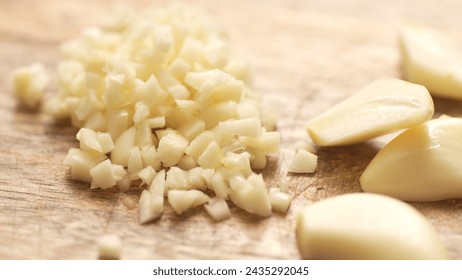 Chopping garlic with halves on a cutting board. Close-up, shallow dof.