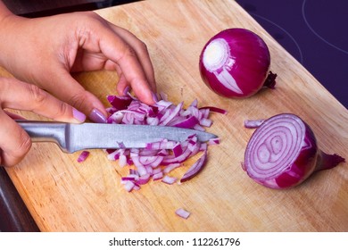 Chopping Red Onion On The Kitchen Cutting Board