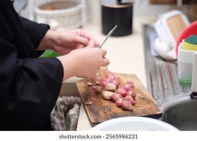 chopping shallots at kitchen table 