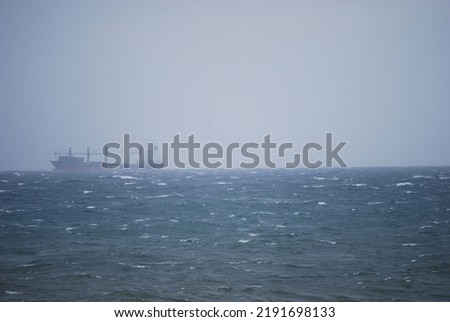 Choppy ocean with freightliner ship on the horizon
