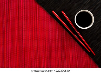 Chopsticks and bowl with soy sauce on bamboo mat - Powered by Shutterstock