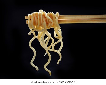 Chopsticks With Noodles On Black Background