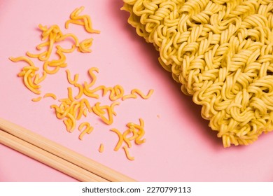 Chopsticks and raw instant noodles on pink background, close-up, flatlay. - Shutterstock ID 2270799113