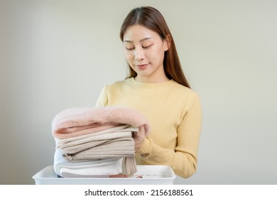 Chore Of Housewife, Smile Asian Young Woman Folding Many Freshly Shirts Put The Cloth In The Basket After Washing Clean Clothes And Drying, Making Household Working In Room At Home, Maid Laundry Tidy.