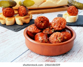 Chorizo Tapas with Pickles and Toasted Bread in a Rustic Setting - Powered by Shutterstock