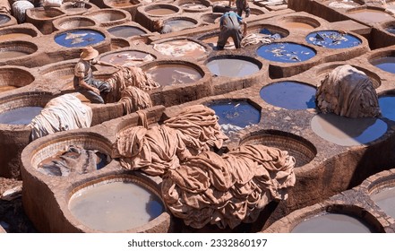 Chouara or Chouwara Tannery, the main tourist attraction in Fez. The vats of softening liquids and dyes. Workers dyeing leather in the stone vessels of the tannery. Authentic leather industry. - Powered by Shutterstock