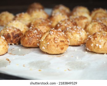 Chouquettes coated with pearl sugar on baking paper