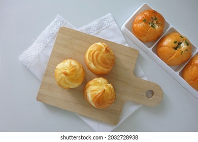 Choux Cream Cake Traditional French Dessert Displayed On Wooden Board. Tasty Creampuff Choux Isolated On White Background                