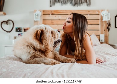 
Chow Chow Dog Licking Girl's Face. Lying In Bed Relaxed And Carefree. Sharing Happiness And Love. Lifestyle