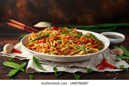 Chow mein, noodles and vegetables dish with wooden chopsticks - Shutterstock ID 1400786087