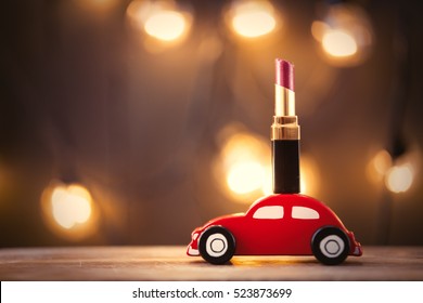 Chrismtas Toy Car And Lipstick With Fairy Lights On Background