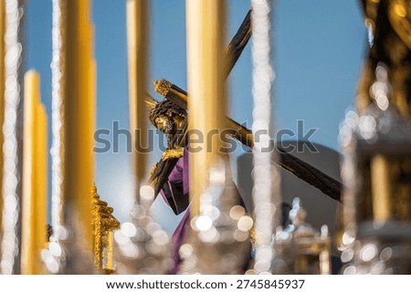 Christ of Gran Poder statue viewed through canopy poles and candles of the Virgin of Mayor Dolor's palio float. Holy Week procession, Seville, Spain.