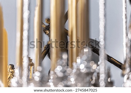 Christ of Gran Poder statue viewed through canopy poles and candles of the Virgin of Mayor Dolor's palio float. Holy Week procession, Seville, Spain.