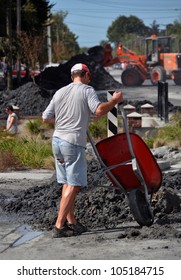 CHRISTCHURCH, NEW ZEALAND - FEBRUARY 24: Unknown Man Wheelbarrows Earthquake Liquefaction From His House On February 24, 2011 In Christchurch.