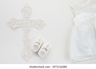 Christening Background With Baptism Dress, Shoes, And Cross On Pastel Background