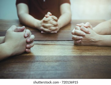 Christian bother and sister are praying together on wooden table ,small prayer group in church, christian background with copy space for your text.
