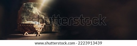 Christian Christmas concept. Birth of Jesus Christ. Wooden manger in cave background. Banner, copy space. Nativity scene symbol. Jesus is reason for season. Salvation, Messiah, Emmanuel