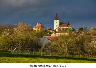 Christian Church And Clergy House Over Village In Spring Nature 