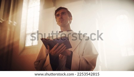 In Christian Church: Portrait of The Minister In Silently Praying, Reads From The Holy Book, The Bible, Gospel of Jesus Christ, Prophet. Priest Seeking Hope, Wisdom, Guidance in the Words of Lord