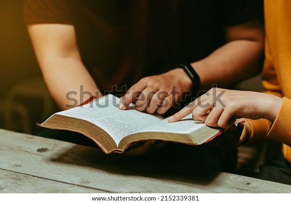 Christian couples read and study the Bible at\
home or in Sunday school. Sunday readings, spirituality, and\
religion Concept.