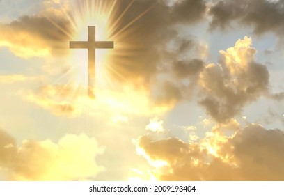 Christian cross appears bright in the gold sky background