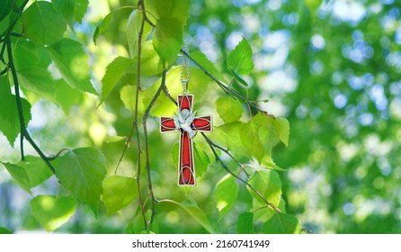 Christian cross with image of a dove on birch branches, abstract green natural background. symbol of Holy Spirit. Holy Trinity Sunday, festive Pentecost day. Faith in God, Church holiday concept
