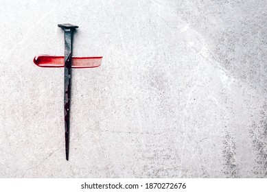 Christian cross made with rusty nails, drops of blood on grey background. Copy space. Good Friday, Easter day. Christian backdrop. Biblical faith, gospel, salvation concept. Jesus Christ Crucifixion.