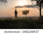 Christian cross on sunset background. Cross silhouette and the clouds at sunset.