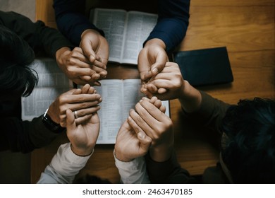 Christian Family prayer and worship. Christian group of people holding hands and praying worships to believe and Bible on a wooden table prayer meeting concept. Church Community pray together - Powered by Shutterstock