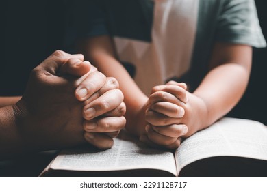 Christian family praying together concept. Child and mother worship God in home. Woman and boy hands praying to god with the bible begging for forgiveness and believe in goodness. - Shutterstock ID 2291128717