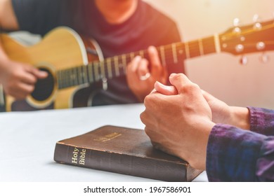 Christian Family Worship God In Home, With A Guitar And The Holy Bible. Praise And Worship Concept