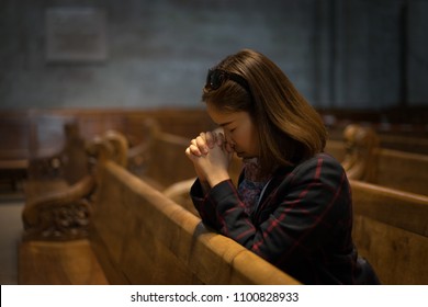 A Christian Girl Is Sitting And Praying With Humble Heart In The Church.