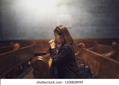 A Christian Girl Is Sitting And Praying With Humble Heart In The Church.