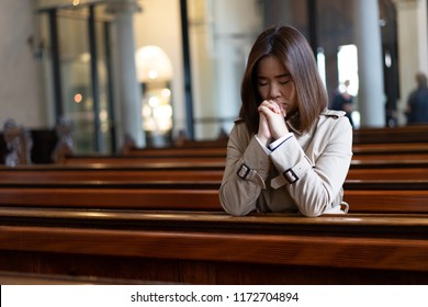 A Christian Girl Is Sitting And Praying With Humble Heart In The Church.