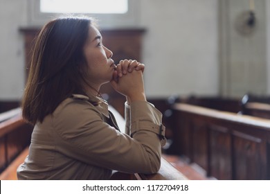 A Christian Girl Is Sitting And Praying With Humble Heart In The Church.